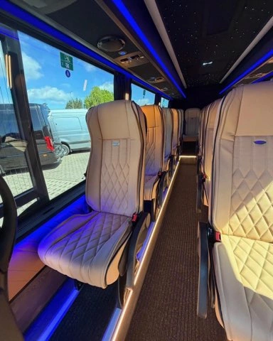 Rząd skórzanych foteli w busie VIP z widokiem przez okno