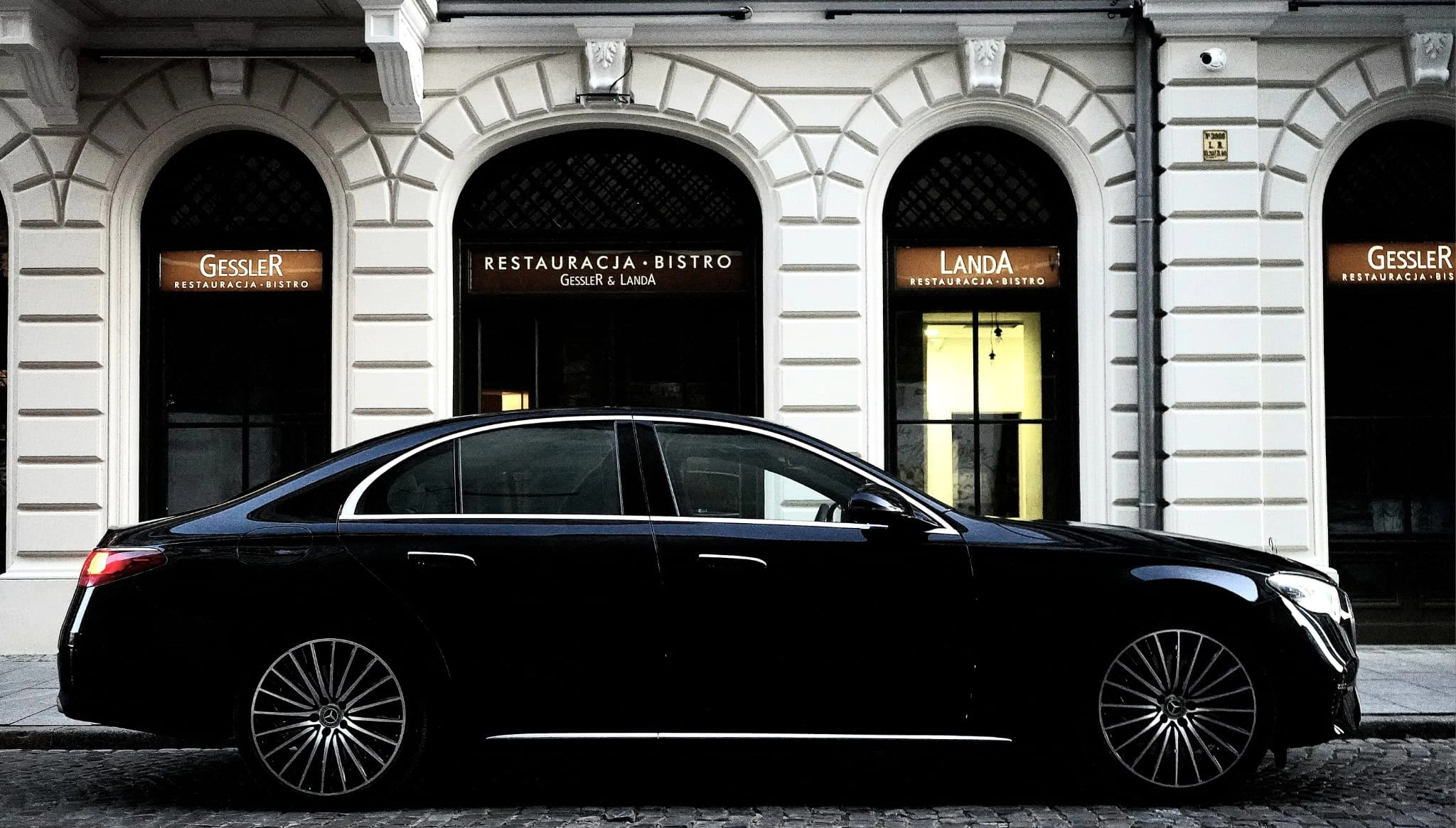 Mercedes klasy S podstawiony pod wejście do restauracji