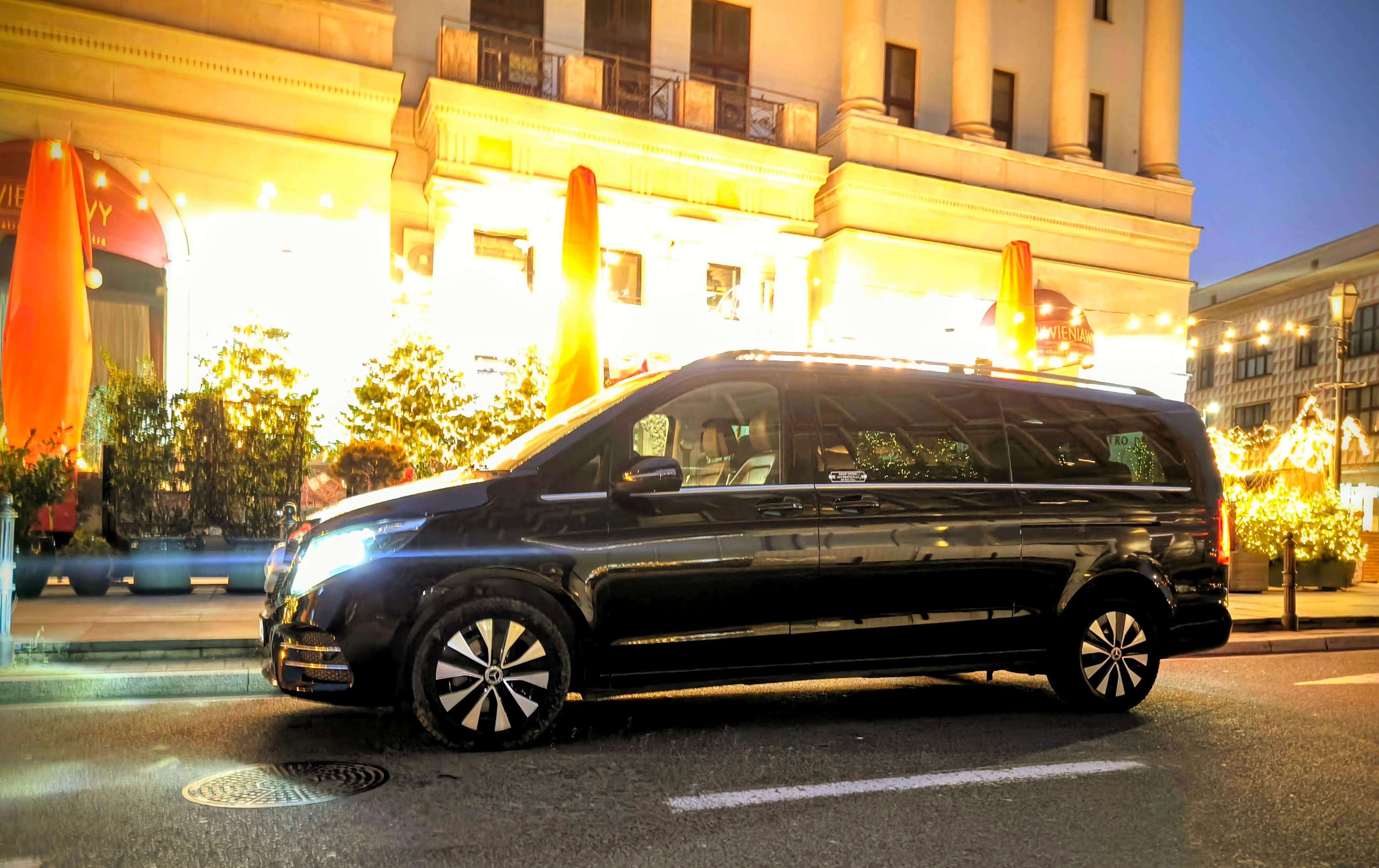 Mercedes klasy V nocą przed oświetlonym budynkiem
