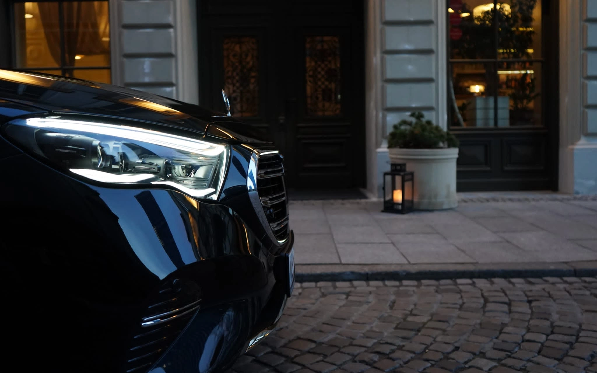 Czarny Mercedes klasy V podstawiony przed wejściem do hotelu
