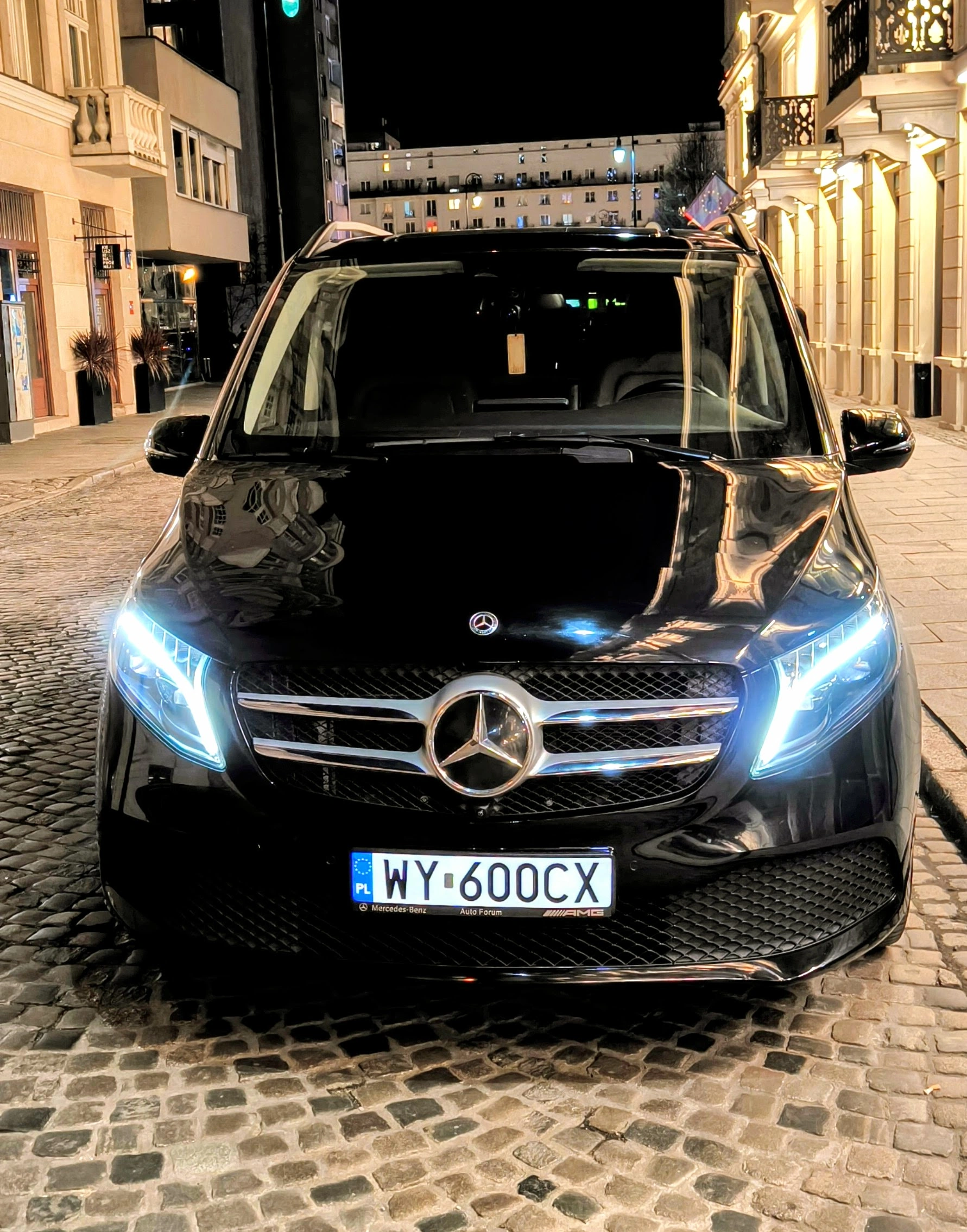Przód Mercedesa klasy V z włączonymi reflektorami nocą